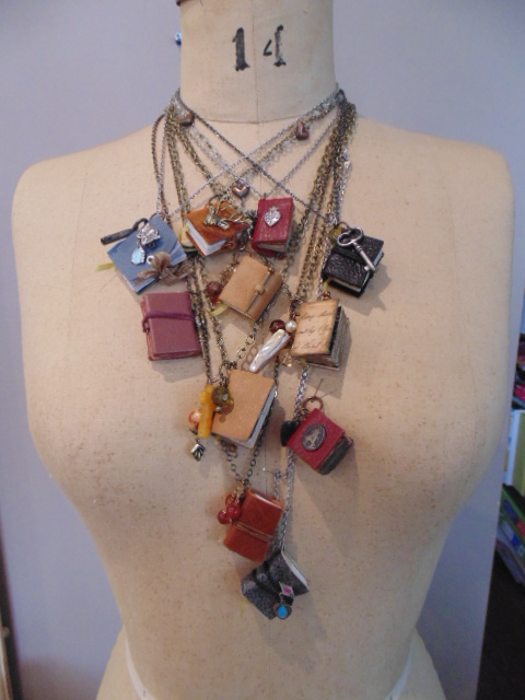 Mannequin with many mini book pendant necklaces
